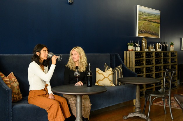 Guests being served wine at the bar inside the Maison Bleue Tasting Room
